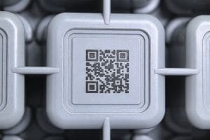 Permanent QR code laser marked on a grey plastic industrial part, demonstrating sharp edges and zero thermal deformation.